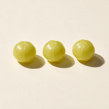 Fresh amla fruits (Phyllanthus emblica) on a seamless off-white background